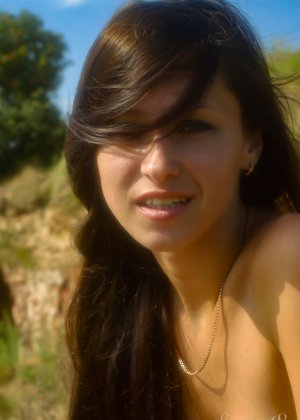 Молодая брюнетка Белланка Л демонстрирует свою обнаженную фигуру на холме на каблуках