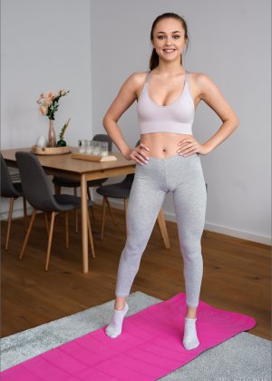 Брюнетка соло девушка снимает одежду из спандекса, чтобы раздеться на своем коврике для йоги