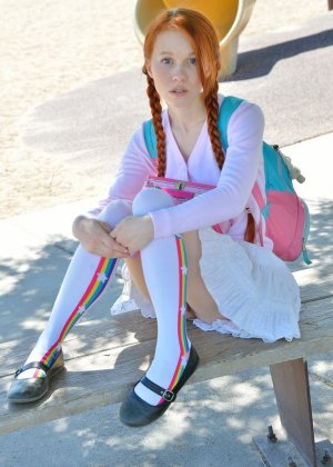 Молодо выглядящая девушка прикрывает свои сиськи носками выше колен и короткой юбкой